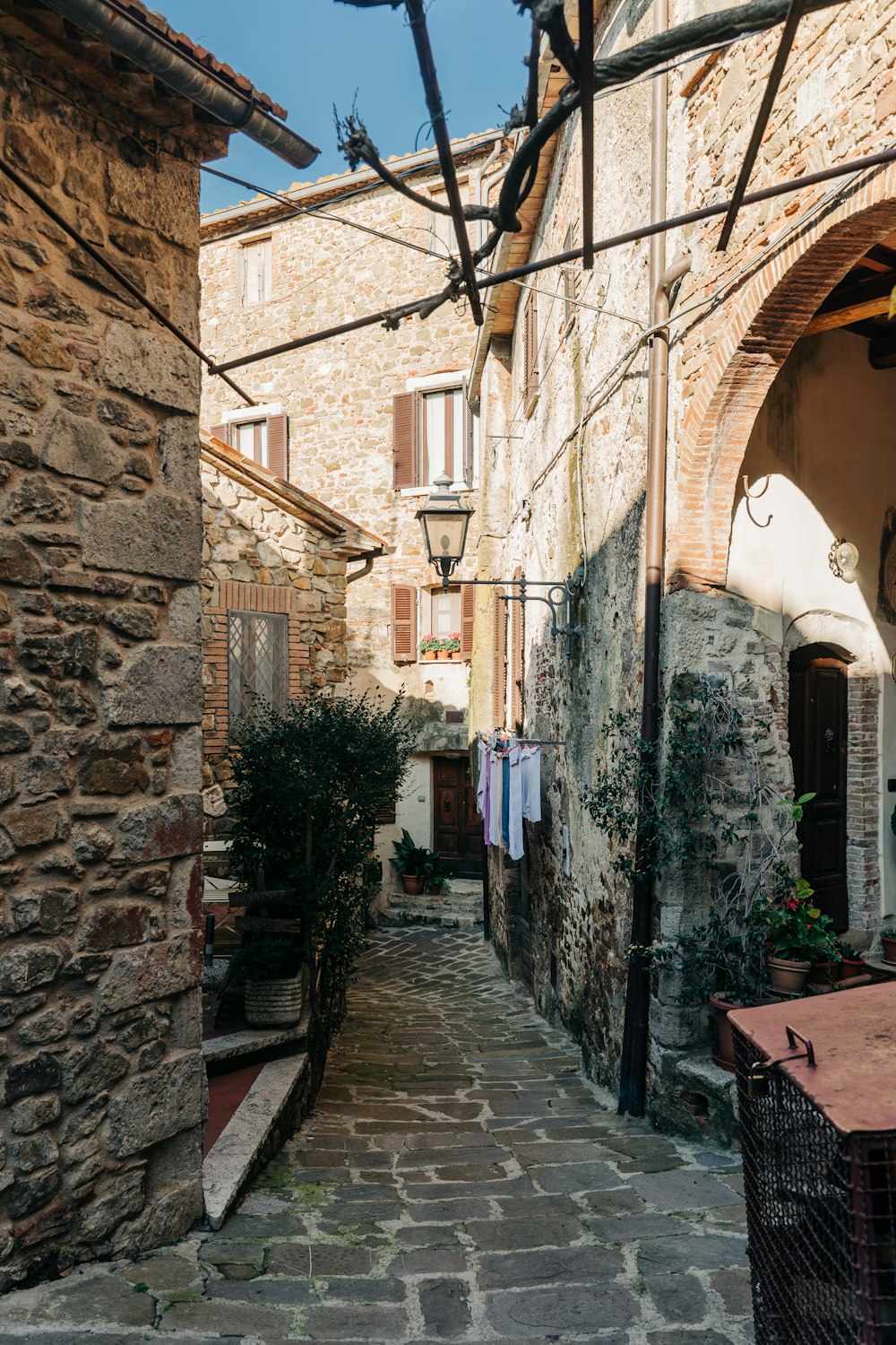 a narrow alley way with stone buildings and a laundry line