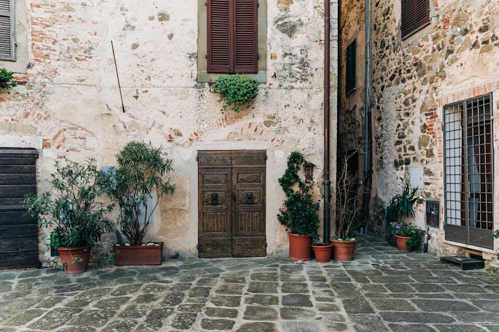 a brick building with potted plants and a wooden door