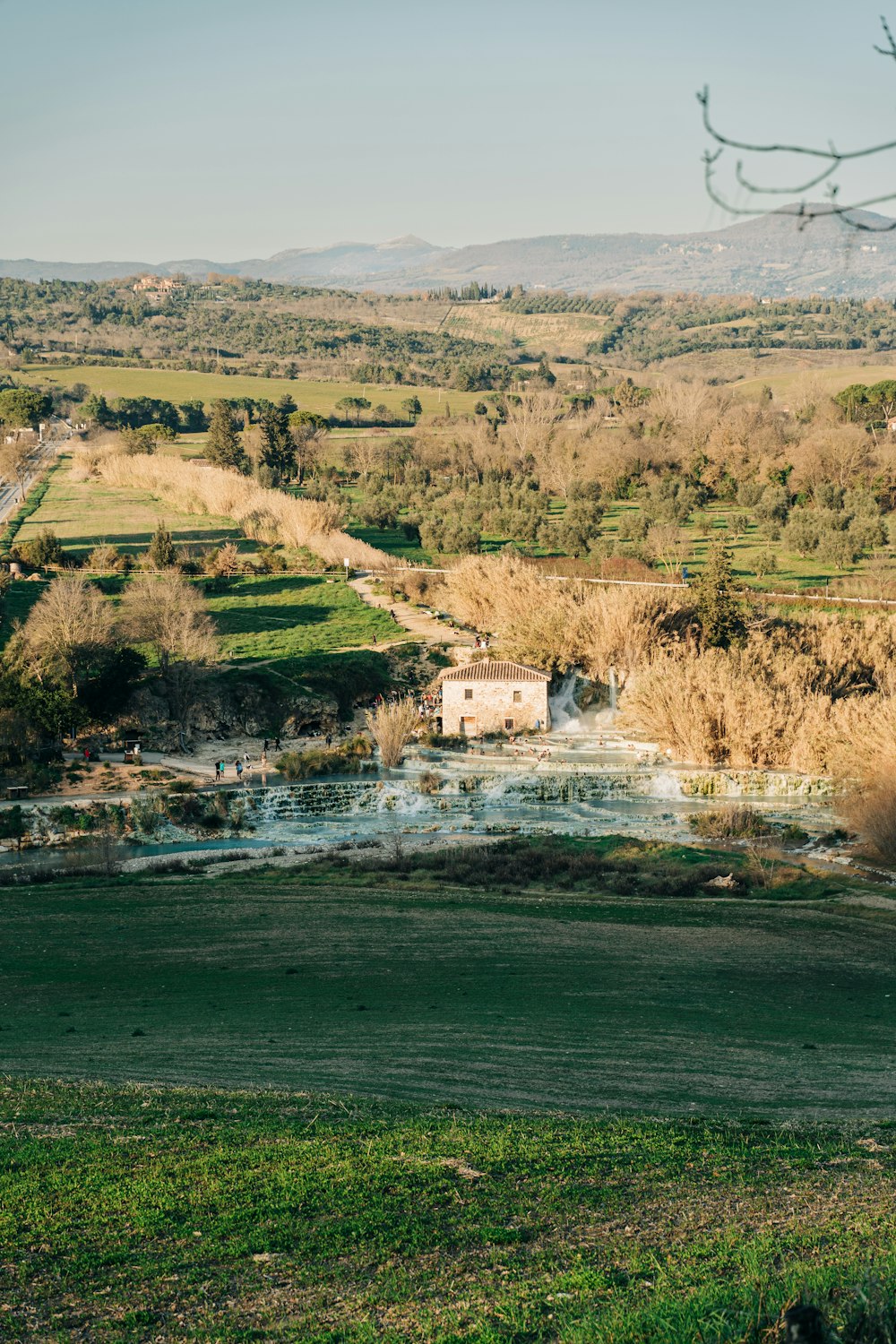 a green field with a small house in the middle of it