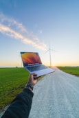 a person is holding a laptop in the middle of a road