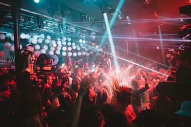 a crowd of people at a concert with lights on