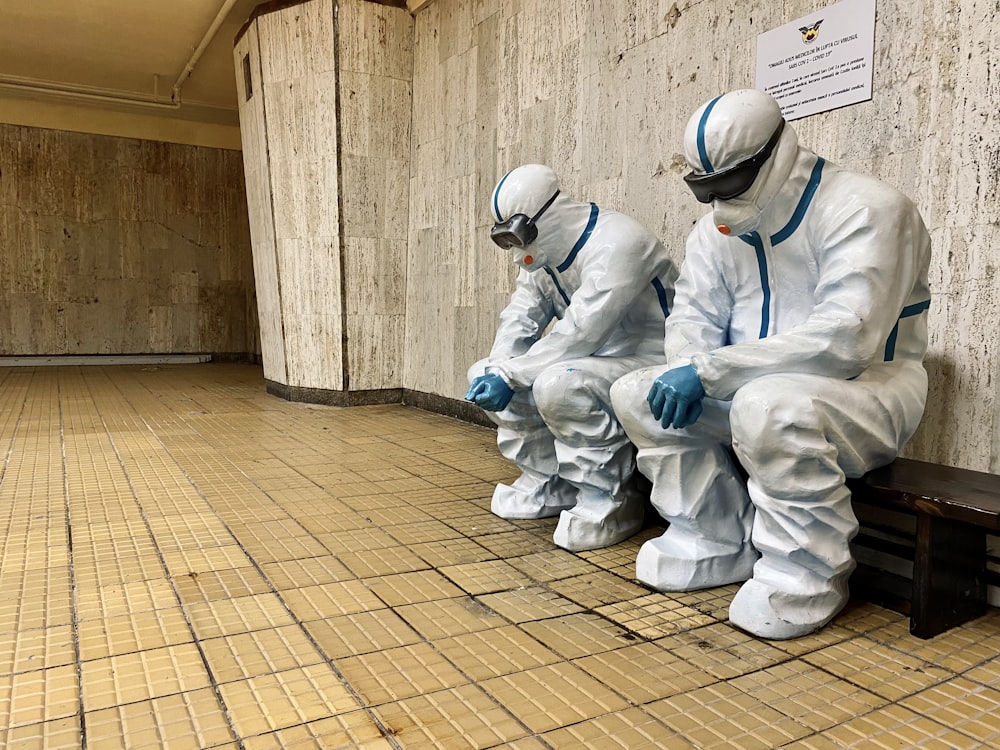 three people in white suits sitting on a bench