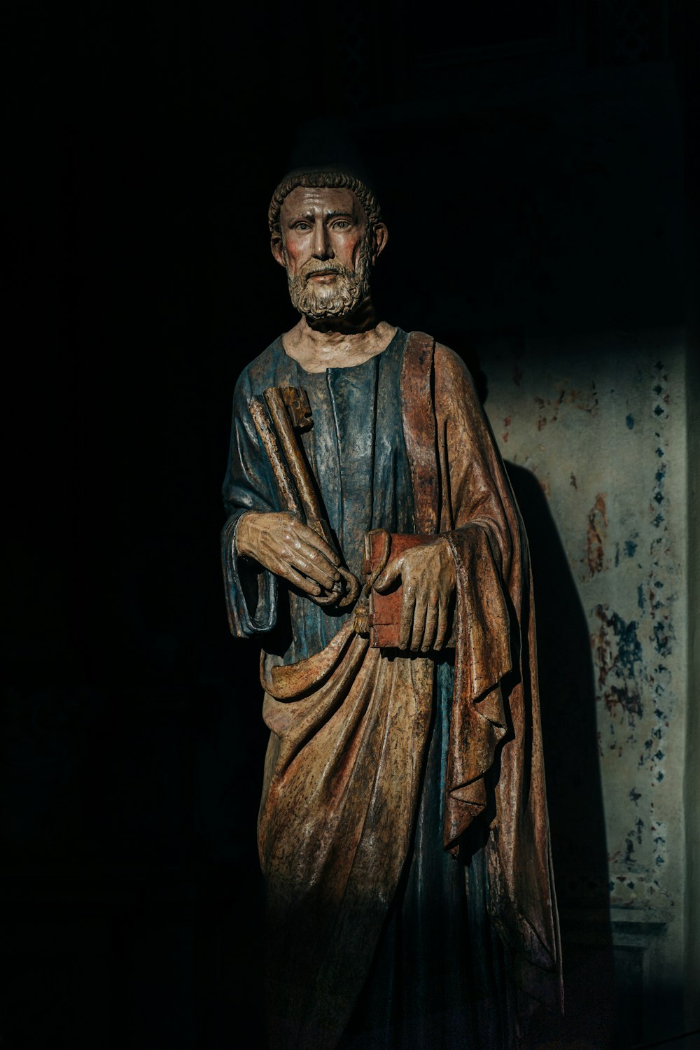 Una statua di un uomo in piedi in una stanza buia