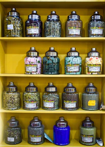 A minimalist shelf displaying jars of dried herbs and spices with earthy tones.