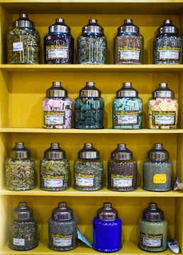 Colorful jars labeled for different savings goals on a wooden shelf.