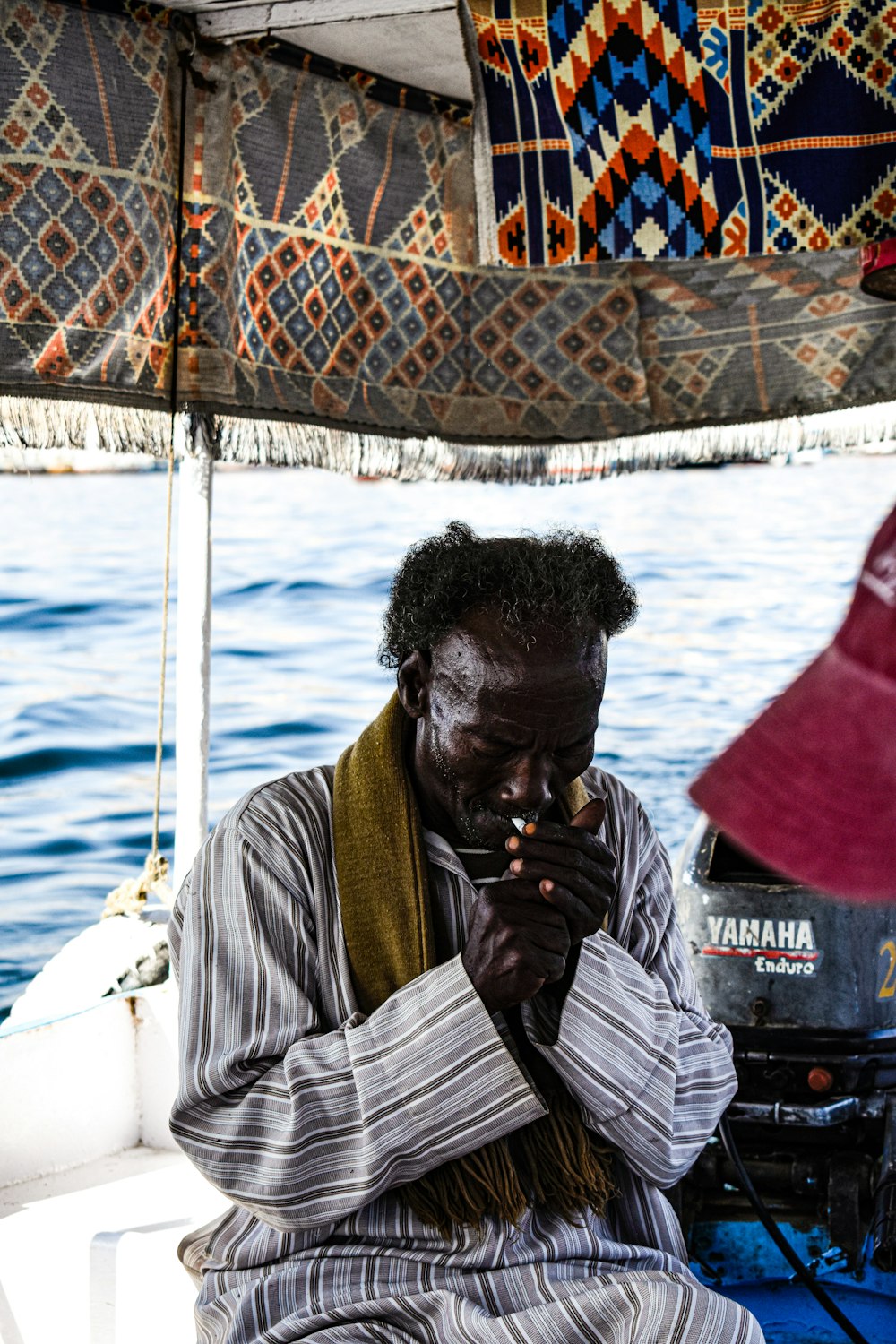 a man sitting on a boat looking at his cell phone