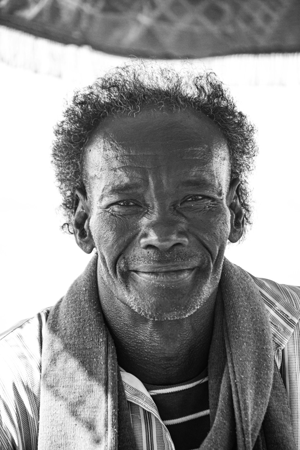 a black and white photo of a smiling man