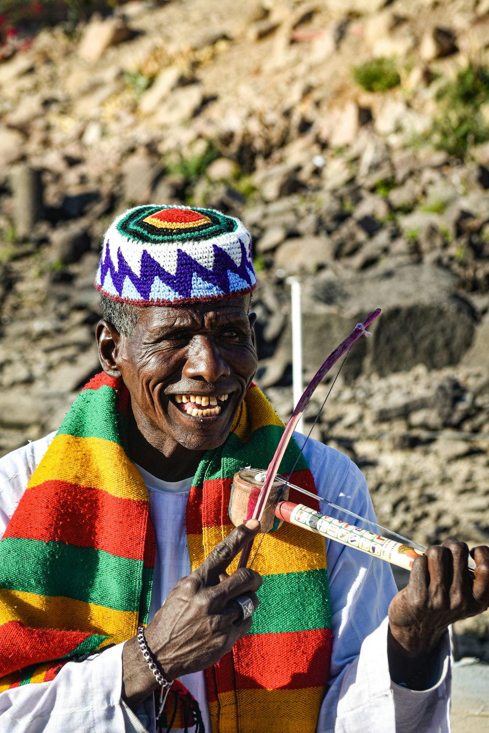 a man in a colorful scarf holding a pair of scissors