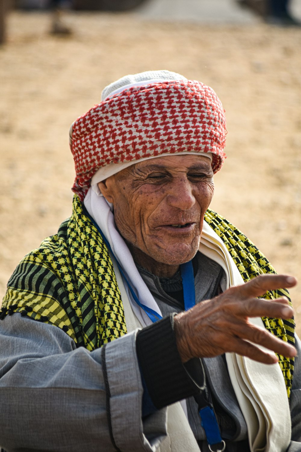 an old man wearing a colorful hat and scarf