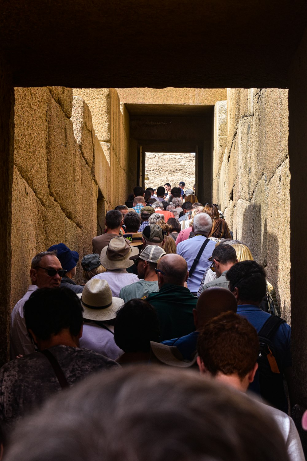 a group of people walking down a narrow hallway