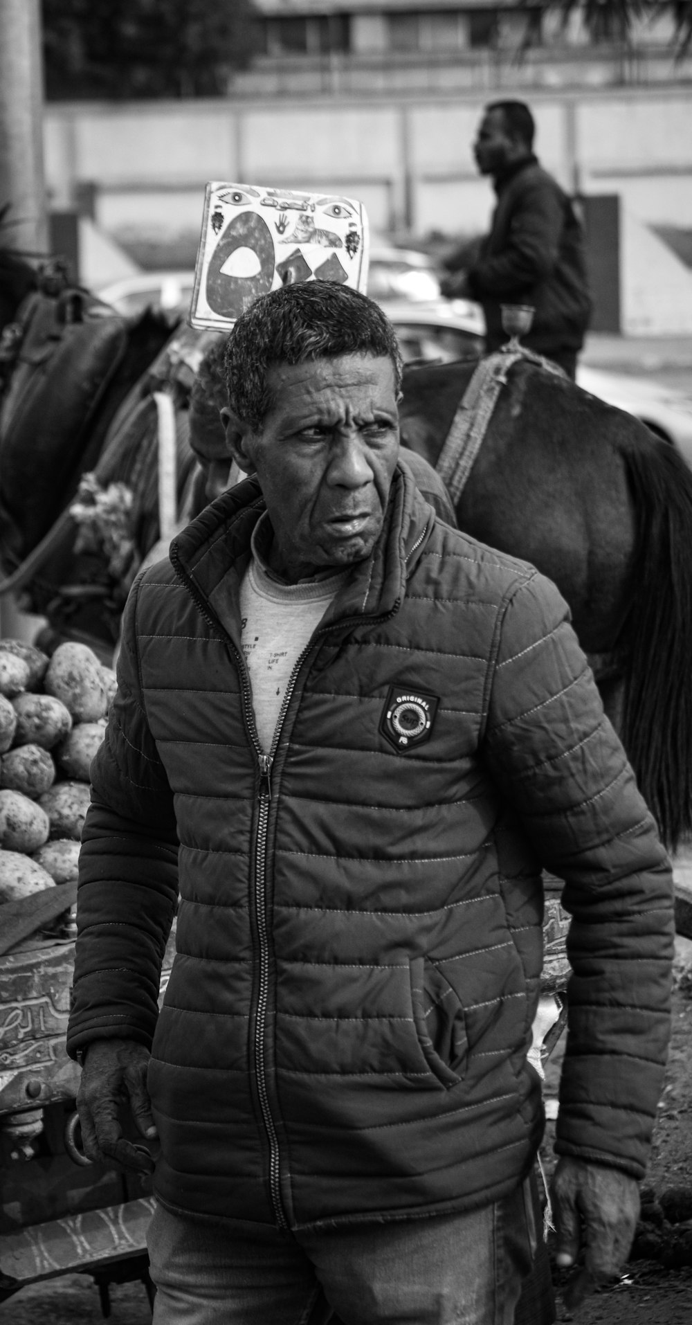 a black and white photo of a man standing next to a horse