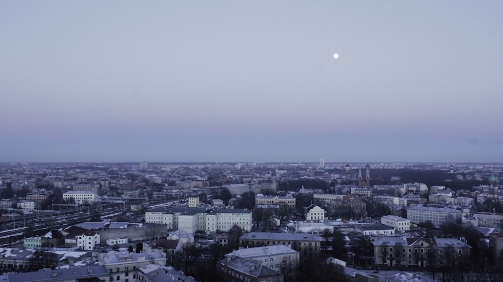 a view of a city with a full moon in the sky