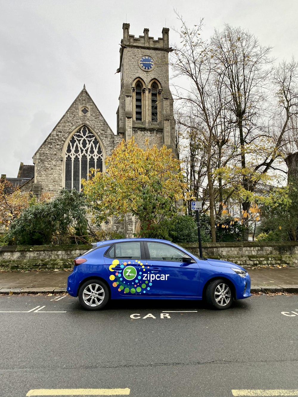 a blue car parked in front of a church