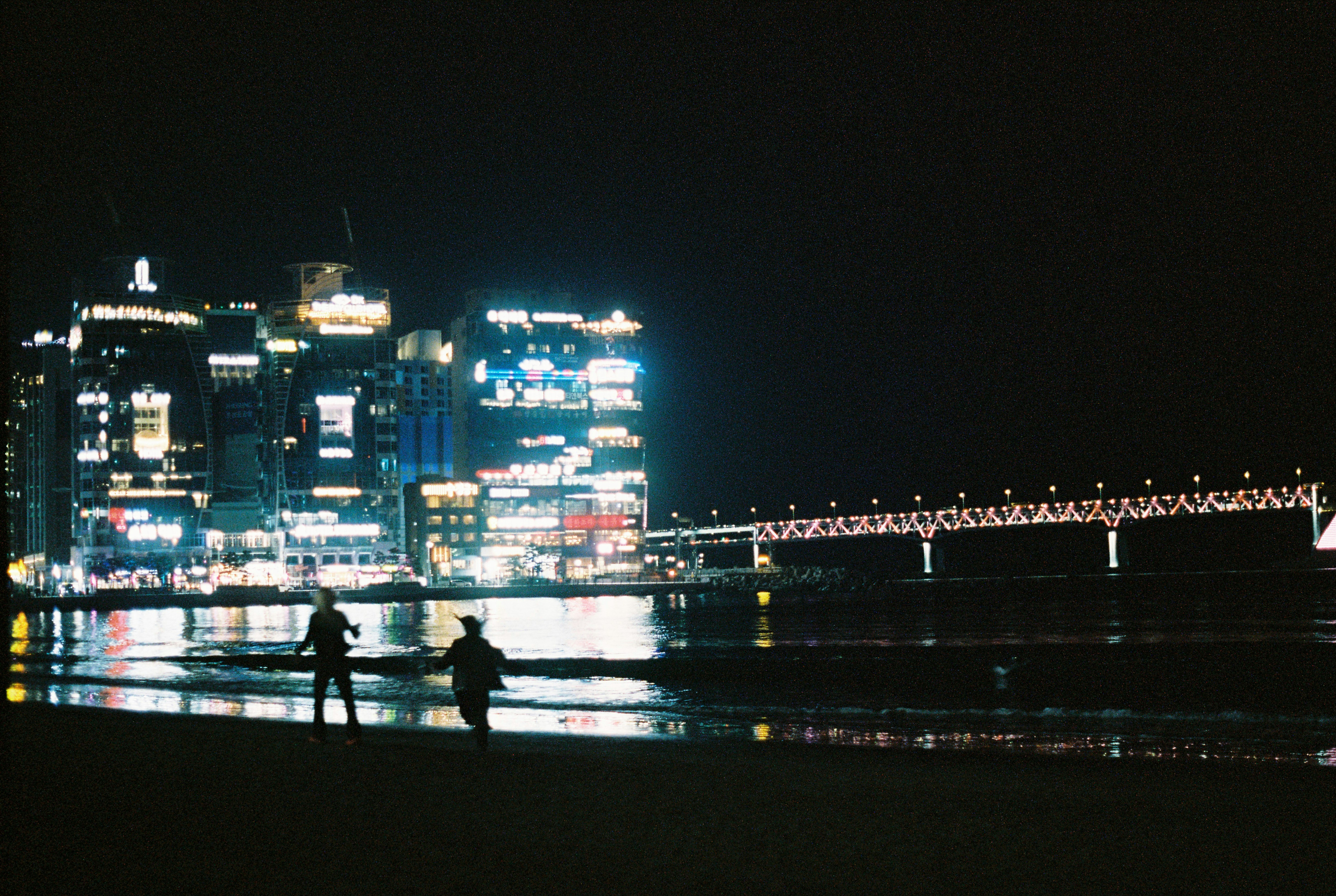 a couple of people standing on top of a beach