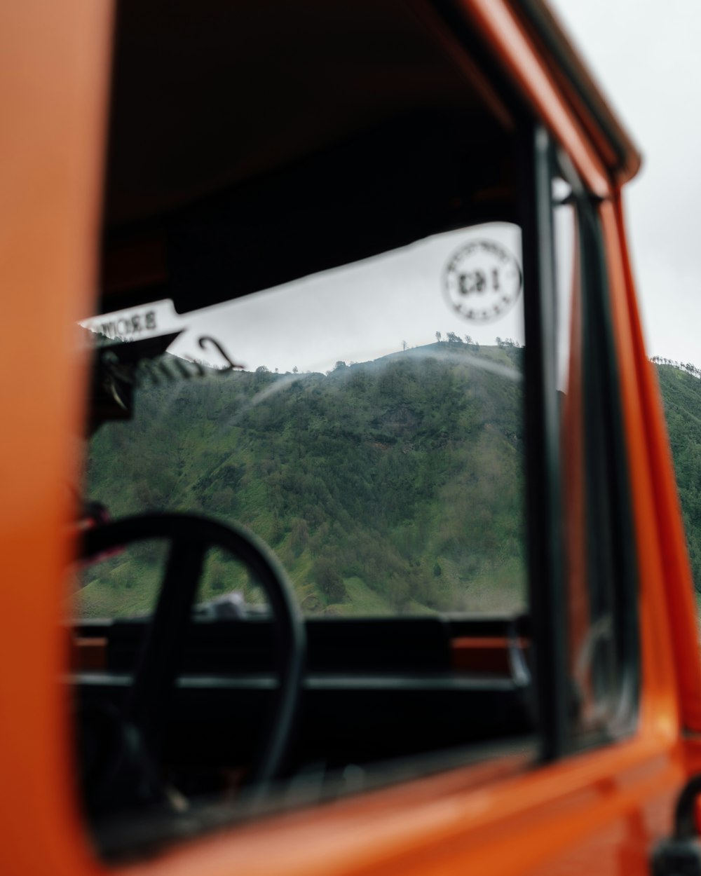 an orange truck with a mountain in the background