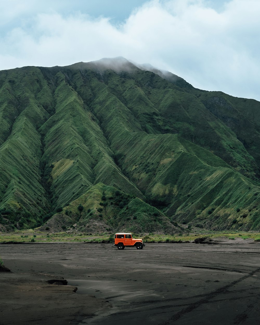 a truck is parked in front of a mountain