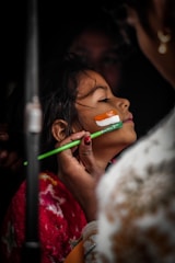 a woman holding a toothbrush to her face