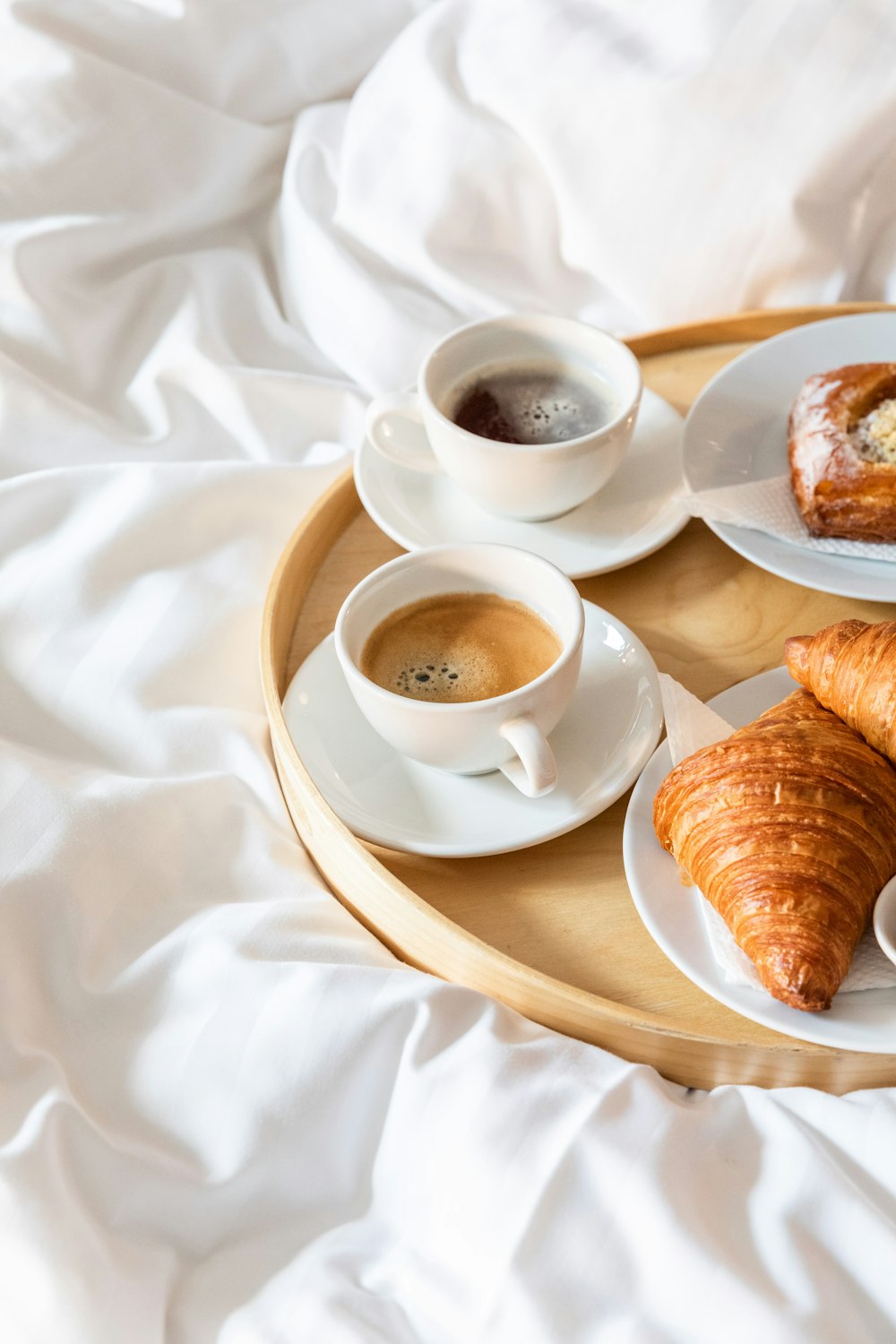 a breakfast tray with coffee, croissants, and croissants