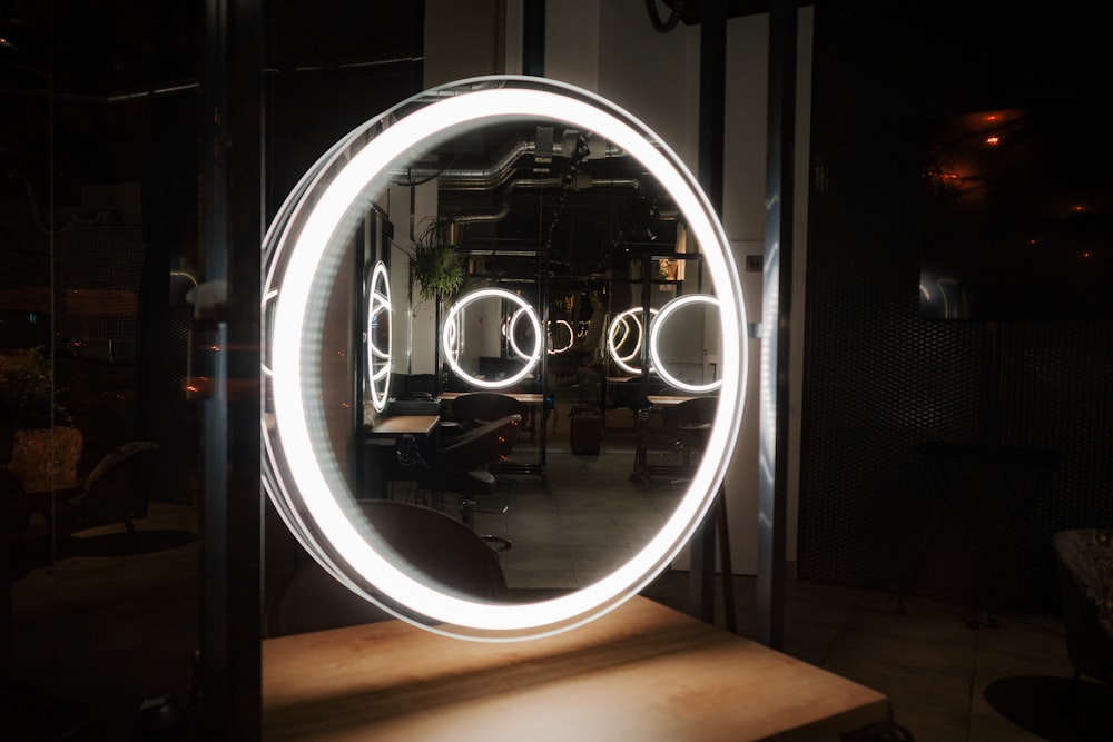 a circular mirror with lights in the middle of it