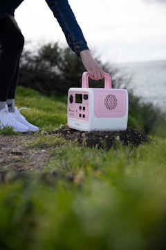 Lifestyle shot of a person enjoying music outdoors with a pinkwave audio speaker