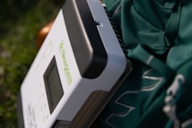 A close-up view of a device with the brand name 'Newpowa' on its surface, resting against a green fabric. The device appears to have buttons and a display screen, and the fabric features white lettering or design.