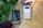 Two hands are holding objects next to some green plants. One hand holds a black and green electronic device with the brand 'Newpowa' displayed. The other hand holds a smartphone showing a product page for a 'Newpowa' 12V/24V PWM Solar Charge Controller, including product ratings and details.
