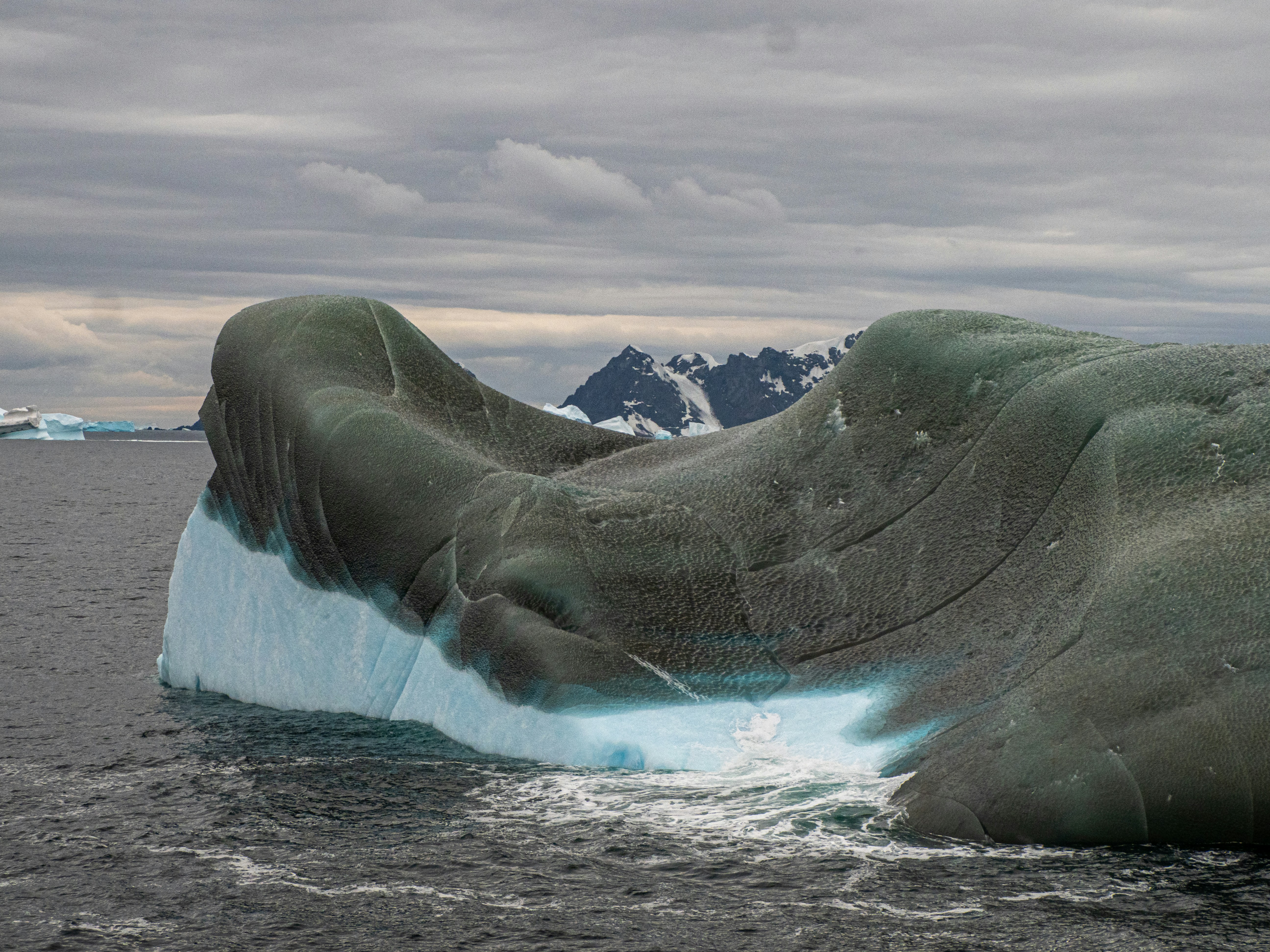 a large iceberg floating on top of a body of water