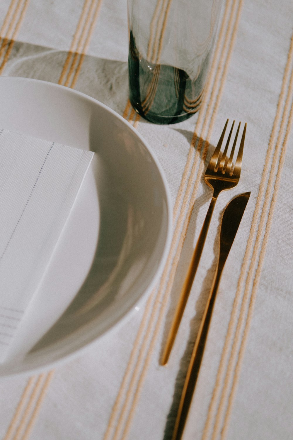 un piatto bianco con forchetta e coltello su un tavolo