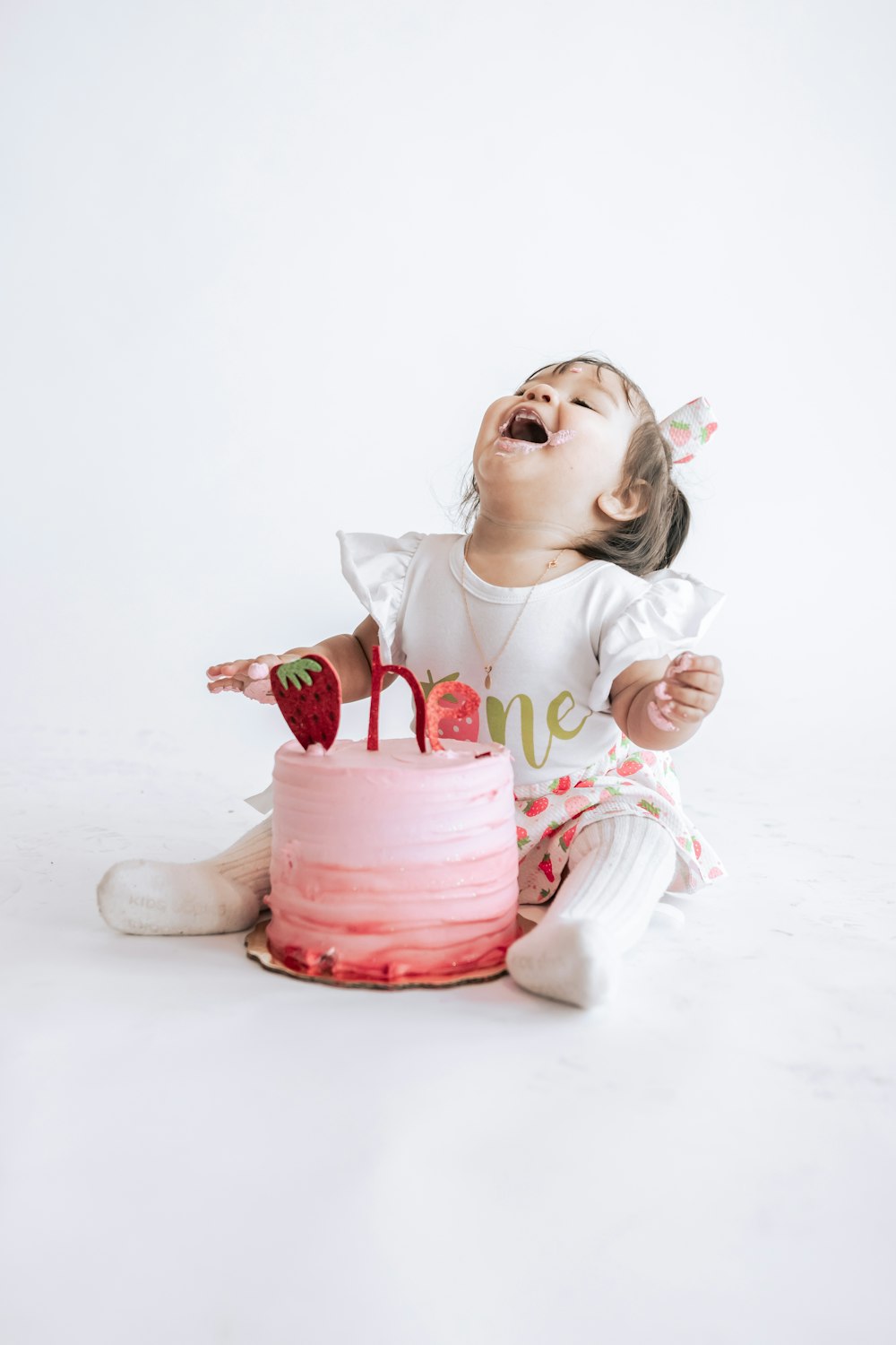 A little girl sitting in front of a pink cake photo – Free Cake Image on Unsplash
