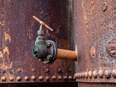 a rusted pipe with a spigot attached to it