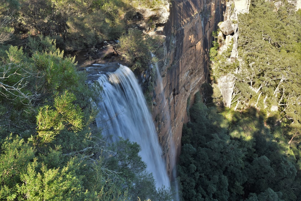 an aerial view of a waterfall surrounded by trees