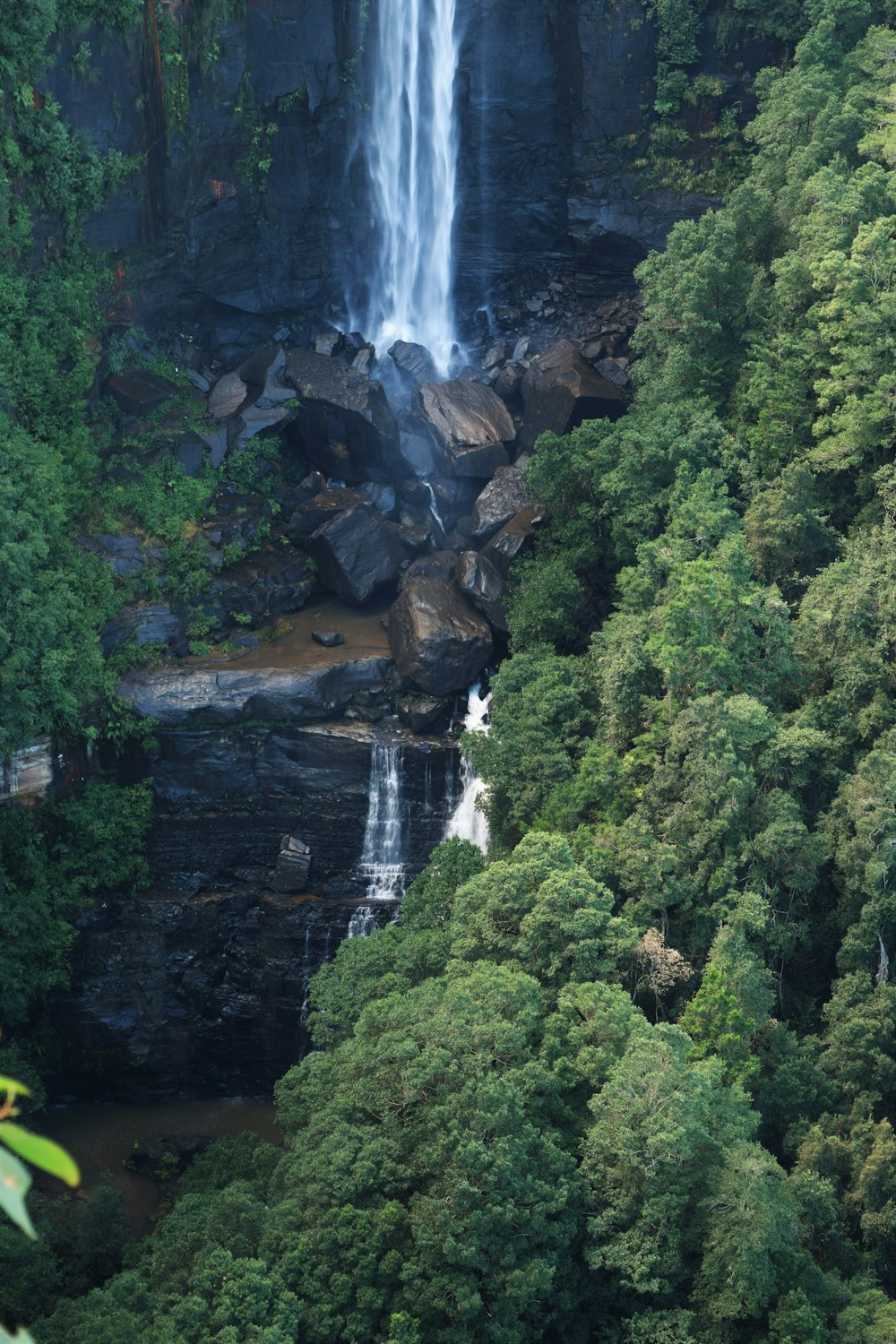 a large waterfall in the middle of a forest