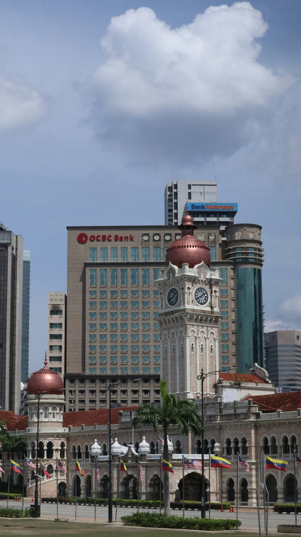 Un grand bâtiment avec une tour de l’horloge au milieu d’une ville