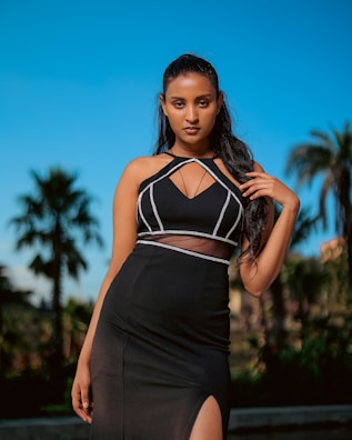 An elegant escort in stylish attire standing by a modern Dubai skyline backdrop.