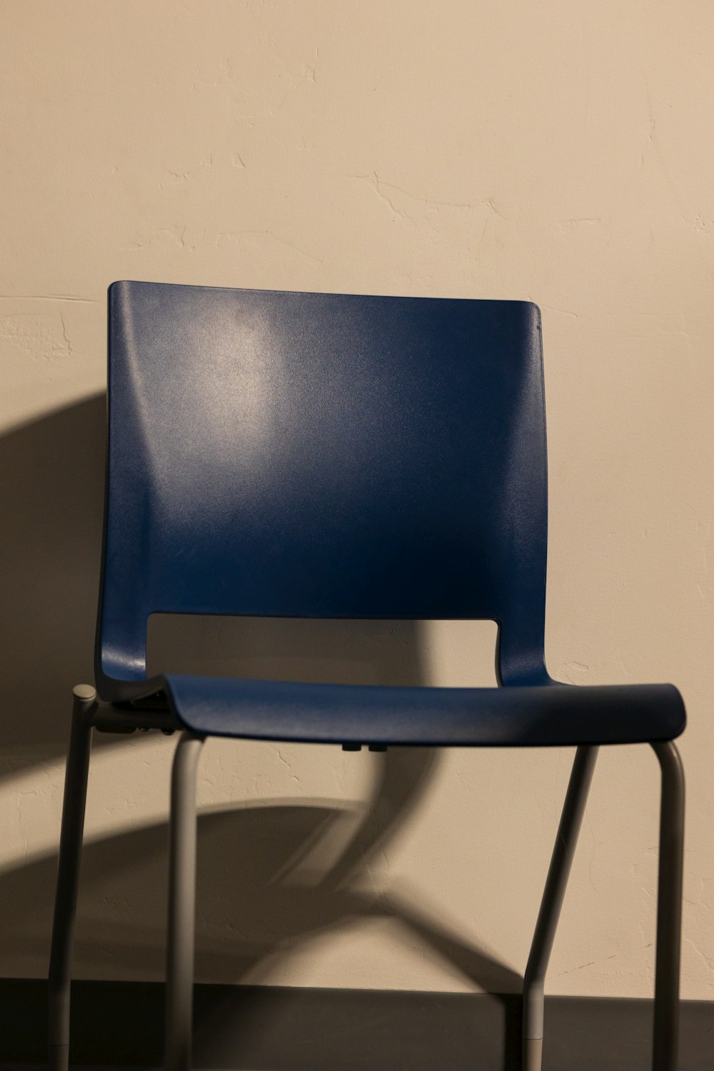 a blue chair sitting in front of a white wall