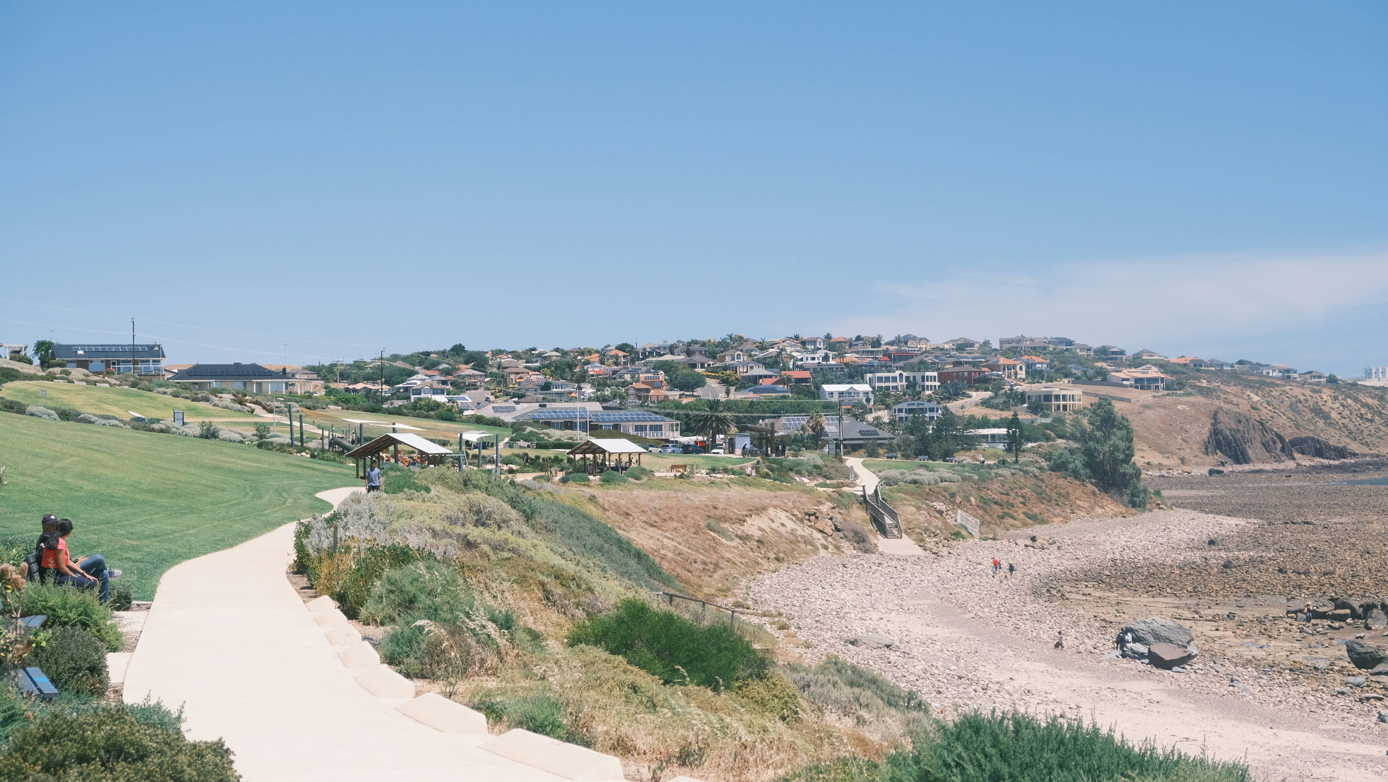 a group of people sitting on top of a lush green hillside