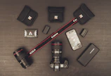 Stylish flat lay of photography and video equipment on a dark surface.