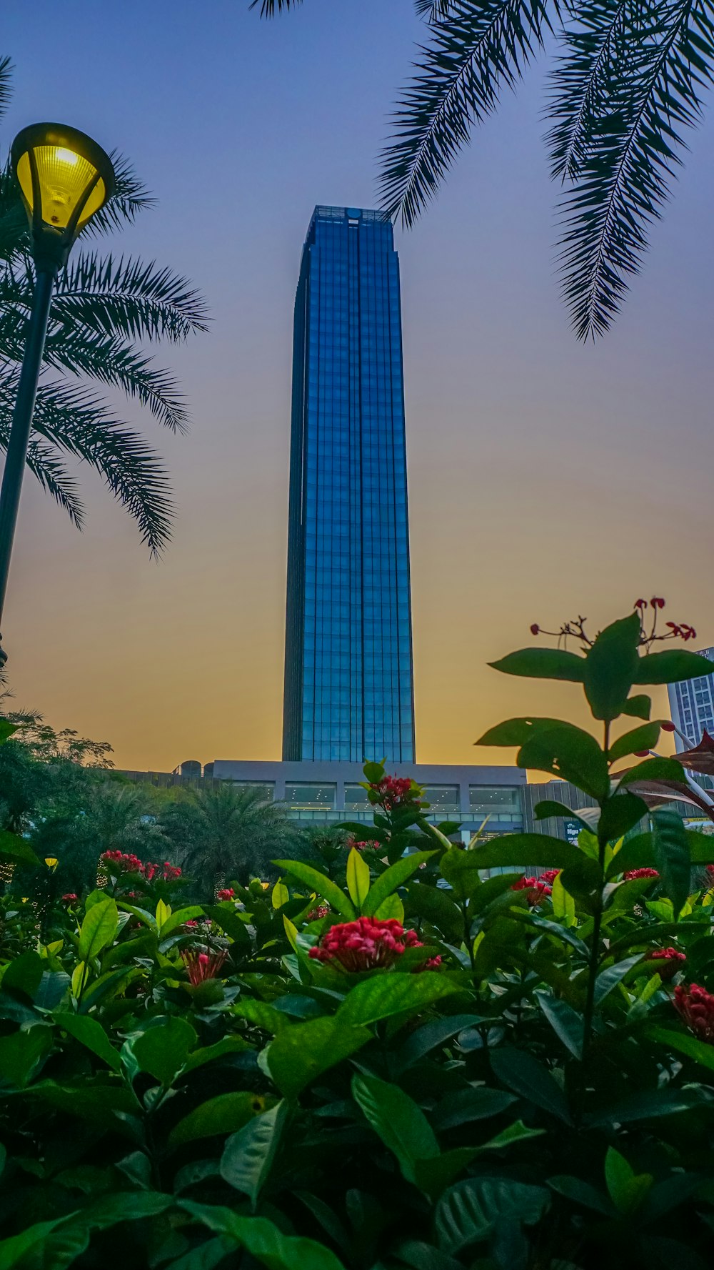 a tall building sitting next to a lush green forest