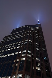 Futuristic skyscraper piercing a twilight sky with glowing windows.