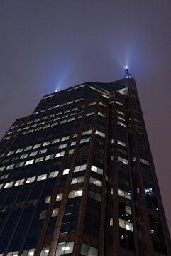 Futuristic skyscraper piercing a twilight sky with glowing windows.