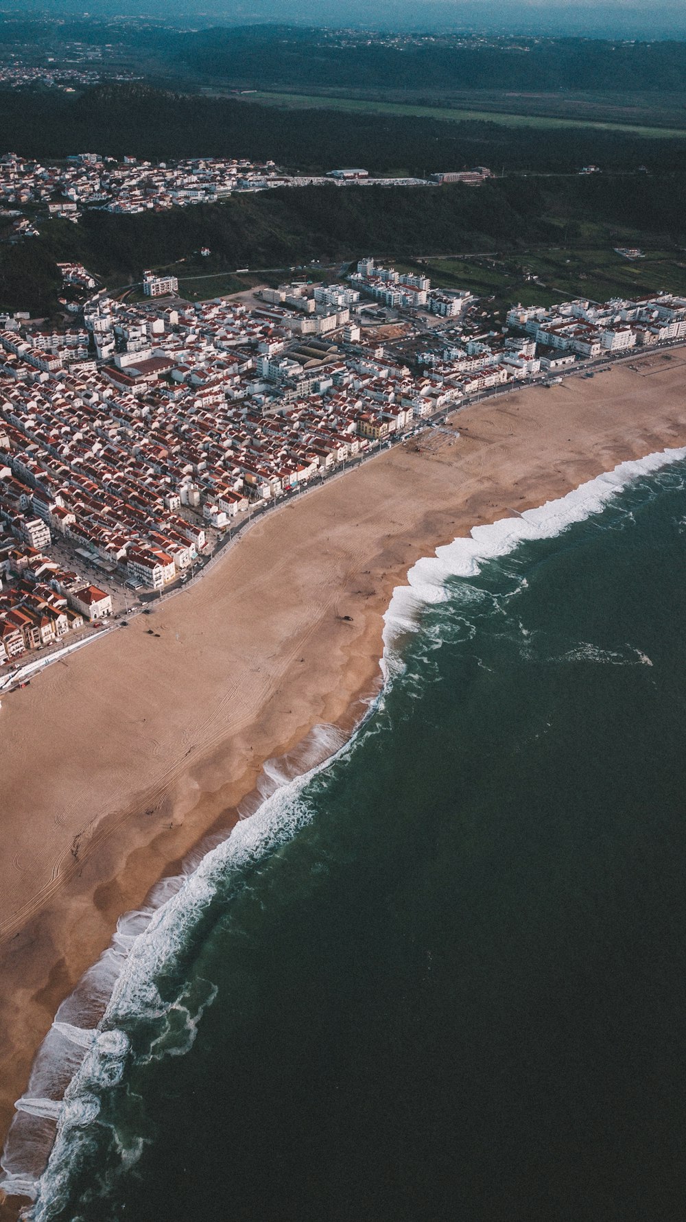 a bird's eye view of a city next to the ocean