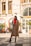 A stylish woman wearing a fashionable coat in an urban setting.