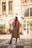 A stylish woman wearing a fashionable coat in an urban setting.