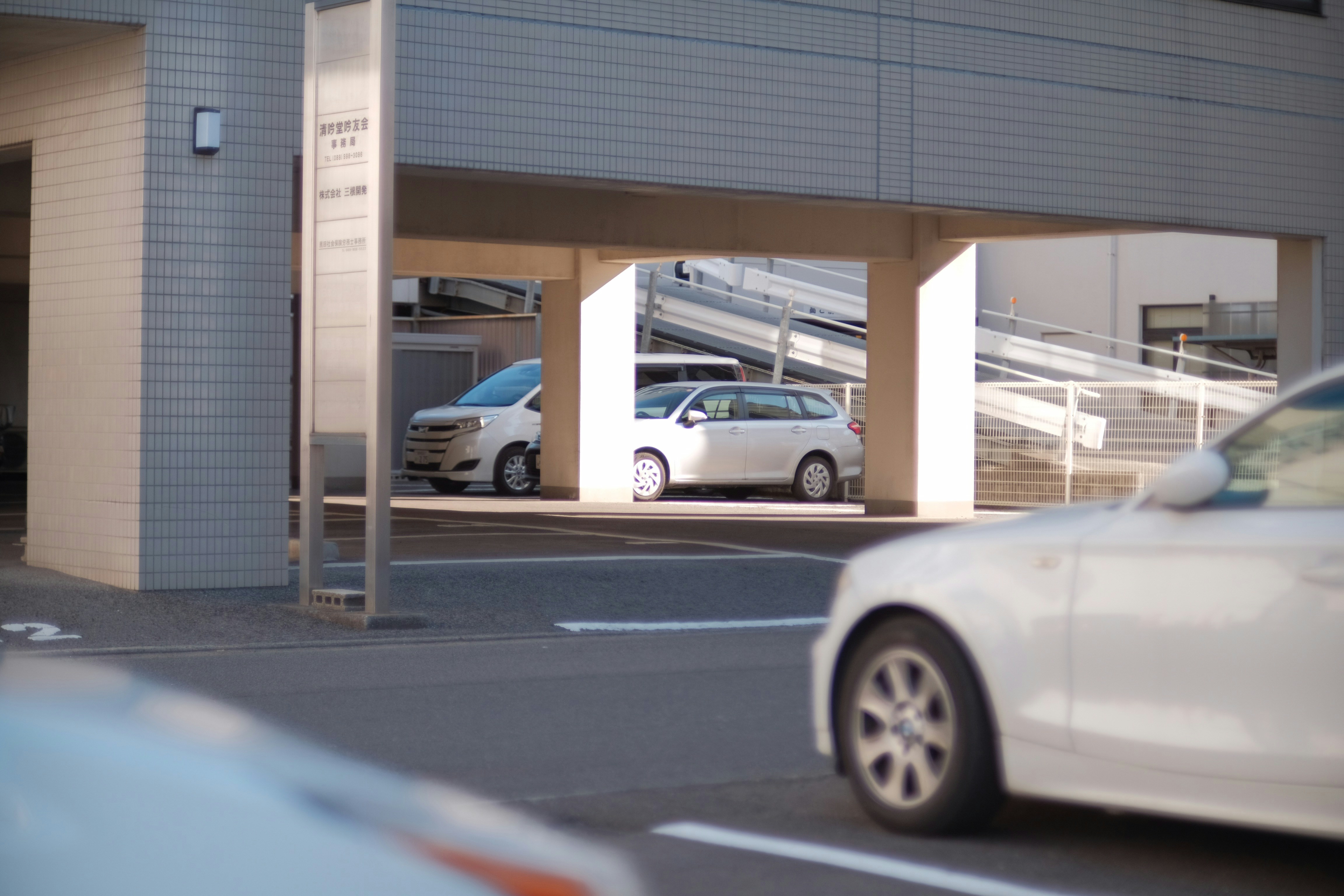 Electric car plugged into a Level 2 charger in an office parking lot