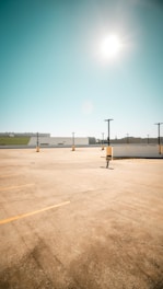 Wide view of a newly paved commercial parking lot with bright striping under a clear sky.