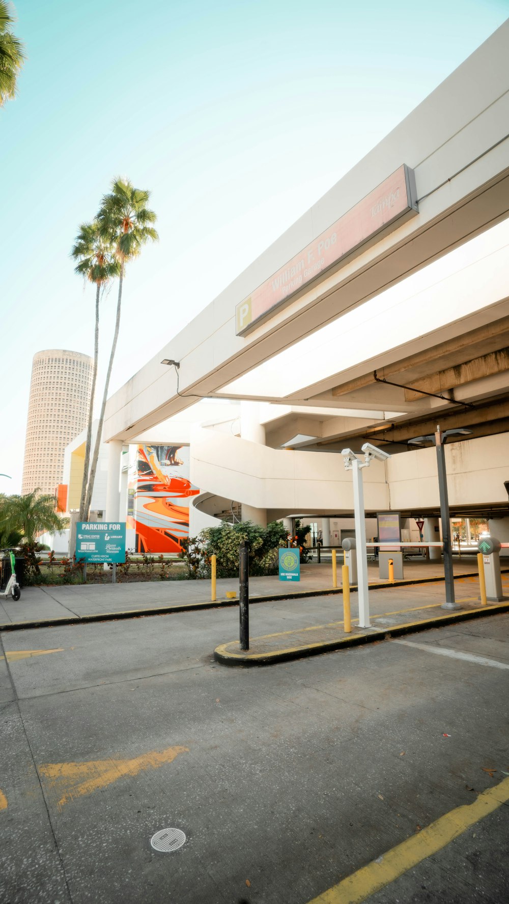 an empty parking lot with palm trees in the background