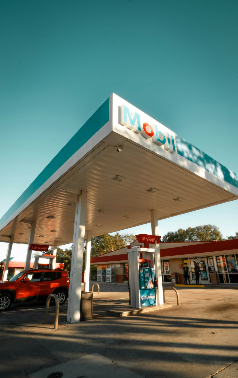 a gas station with a red truck parked in front of it