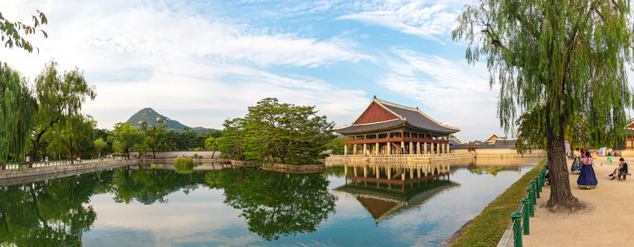 Pavilhão Gyeonghoeru refletido no lago, com árvores verdes na primavera