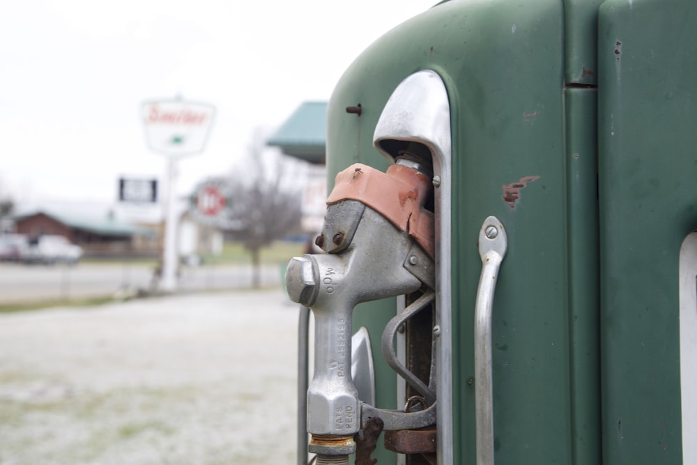 a close up of a fuel nozzle on a green truck