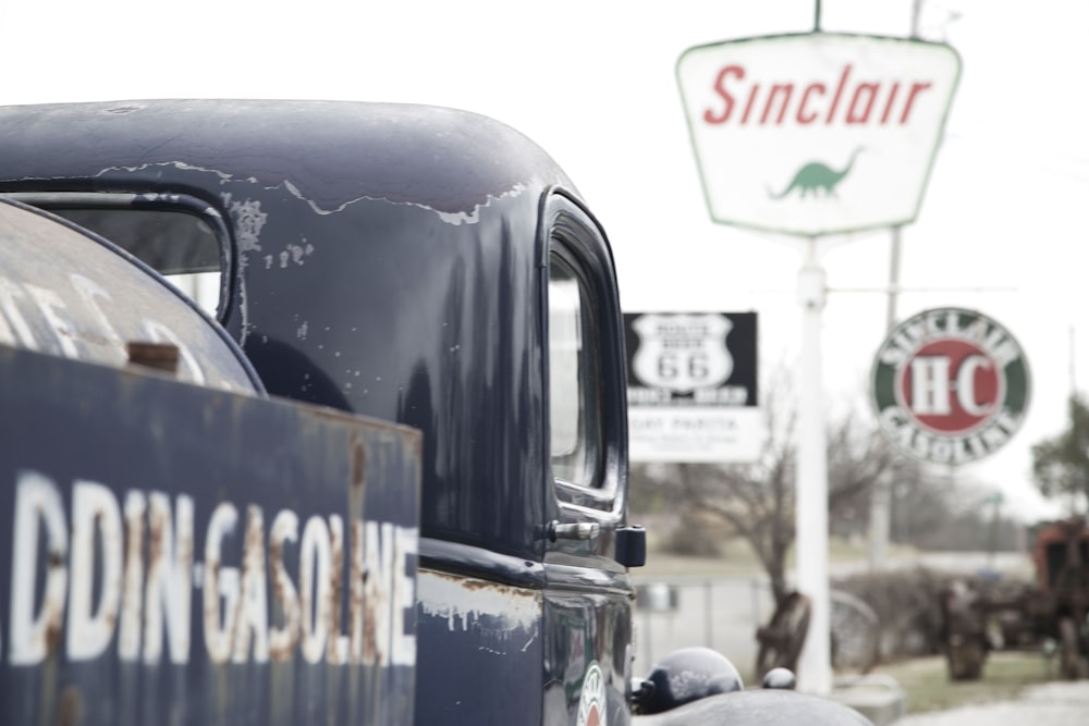 an old truck parked in front of a gas station